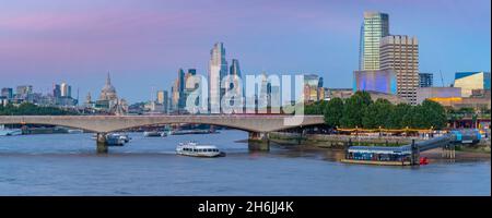 View of Waterloo Bridge over the River Thames, St. Paul's Cathedral and The City of London skyline at dusk, London, England, United Kingdom, Europe