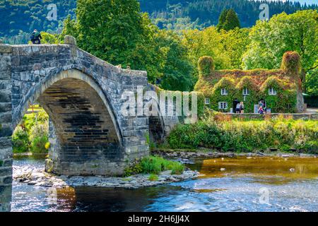 View of Pont Fawr (Inigo Jones Bridge) over Conwy River and cafe, Llanrwst, Clwyd, Snowdonia, North Wales, United Kingdom, Europe Stock Photo