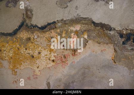 Textured old wall background showing old peeling paints and concrete, with some nail holes on it. Stock Photo