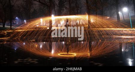 Steel wool sparks reflecting water Long exposure night landscape. Stock Photo