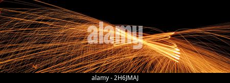 Night fire dance. Sparks from steel wool on a black background. Close-up. Stock Photo