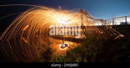 Steel wool sparks reflecting water Long exposure night landscape. Stock Photo