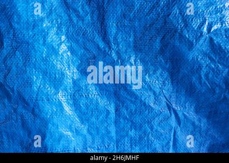 Blue plastic waterproof tarpaulin, textured background, polyethylene sheet. Stock Photo