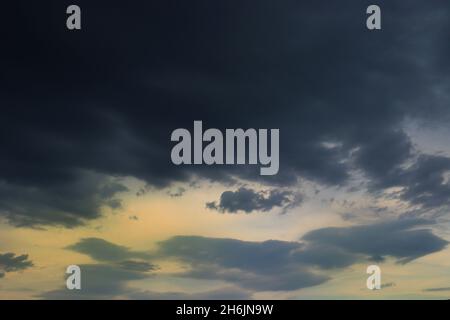 Stormy sky full of dark clouds, covering the sunset light, before the rain. Stock Photo