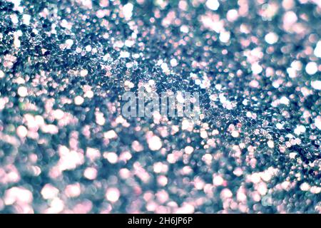 Blue glitter, blurred effect. Glowing holiday light circles are created from bokeh in the camera and lens. Background for design. Christmas background Stock Photo