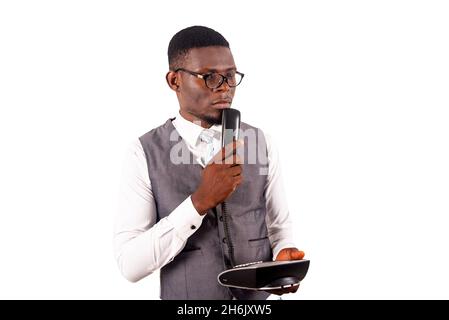 Handsome young businessman wearing eyeglasses thinking about who to call with the help of a landlines. isolated on white background Stock Photo