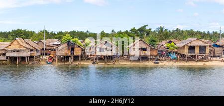 AUKI, SOLOMON ISLANDS - Dec 12, 2016: Traditional thatched houses overlooking Auki harbour in Malaita province of the Solomon Islands. Stock Photo