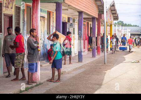 AUKI, SOLOMON ISLANDS - Dec 12, 2016: Shoppers in front of a row of shops on the main street of Auki, the capital of Malaita Province in the Solomon I Stock Photo