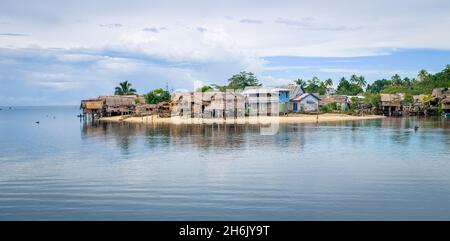 AUKI, SOLOMON ISLANDS - Dec 12, 2016: Traditional thatched houses overlooking Auki harbour in Malaita province of the Solomon Islands. Stock Photo