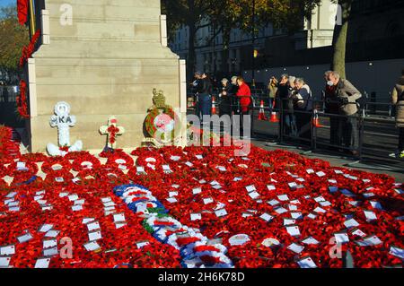 London, UK. 16th Nov, 2021. People stop to read wreaths and poppies at the Cenotaph in Whitehall 2 days after Remembrance Sunday. Credit: JOHNNY ARMSTEAD/Alamy Live News Stock Photo