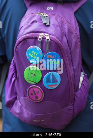 Badges are seen on the backpack of a participant as climate activists rally during Extinction Rebellion's Rise and Rebel March in central London. Stock Photo