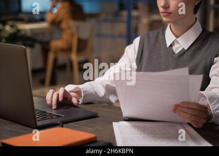 Young businesswoman working with documents using laptop at her workplace at office Stock Photo