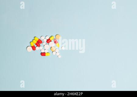 Pharmacy theme, different color medicine tablets antibiotic pills on blue background with copy space for text. Pharmacy. Antibiotics.
