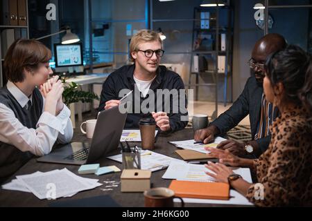 Group of business people planning project together at the table during a meeting while they working at office till late night Stock Photo