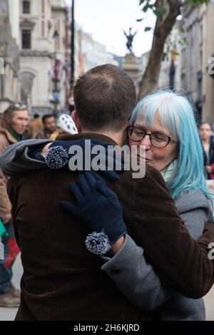 London, UK. 16th November, 2021. One of nine Insulate Britain climate activists is embraced outside the High Court during a break from the hearing of applications brought against them for contempt of court by National Highways. The applications were brought after the activists breached injunctions by blocking the M25 to call on the government to fund the insulation of social housing by 2025 and all homes in Britain by 2030. Credit: Mark Kerrison/Alamy Live News Stock Photo