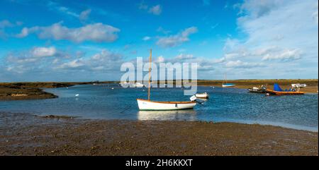 Panoramic view with boats afloat in sunshine at Mow Creek Brancaster Staithe Harbour North Norfolk England Stock Photo