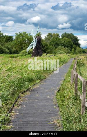 Boardwalk trail looking towards the windmill in Wicken Fen near Cambridge England.. Stock Photo