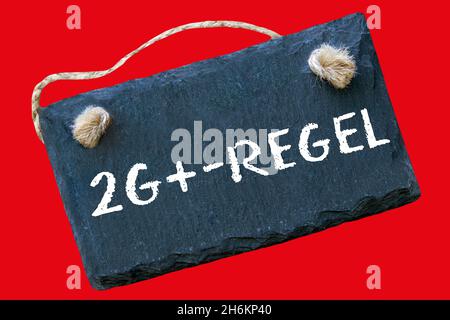German Corona 2G+ Rule and sign against red background closeup Stock Photo