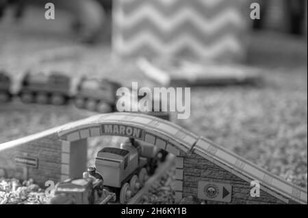 Tiffin, Iowa, USA - 3.2021: Small boy playing with a model Thomas the Train. Thomas is a popular railroad themed children's' toy.  Stock Photo