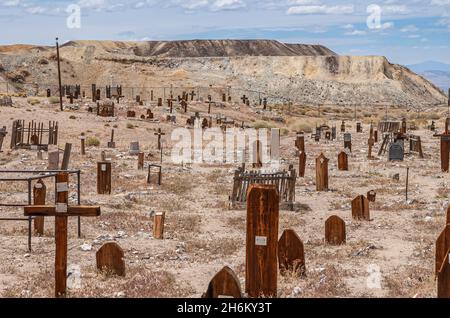 Tonopah, Nevada, US - May 16, 2011: Historic Cemetery. Wide dry light brown desert floor landscape of graveyard with redwood memorials, some of then c Stock Photo