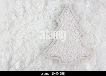 Christmas and New Year concept. The Christmas tree is made from wool on white fluffy background. DIY organic sustainable christmas decoration. Flat la Stock Photo