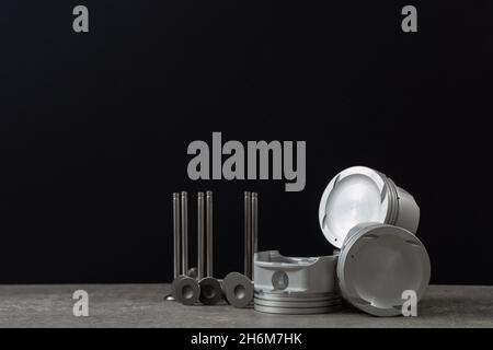 Set of new car pistons and valves on concrete gray background, car repair parts, copy space Stock Photo