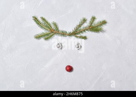 Grey background with a Christmas deer made from a Christmas tree and Christmas decorations. Minimalism. Flat design. A place to copy. Horizontal. Stock Photo