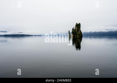 Isolacted rock protruding from the still waters Stock Photo