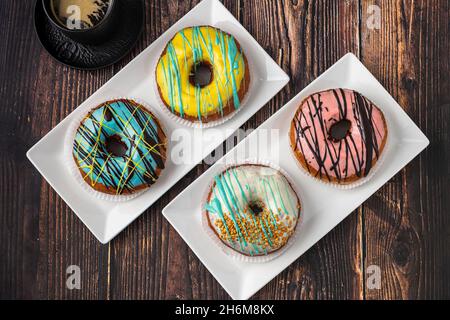 Delicious donuts decorated with different decorations on wooden table Stock Photo