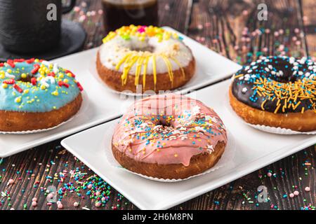 Delicious donuts decorated with different decorations on wooden table Stock Photo