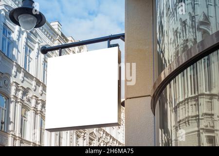 Mock up. Blank white rectangular shape signboard on the wall of classical architecture building. Signage of shop, store, cafe, restaurant Stock Photo