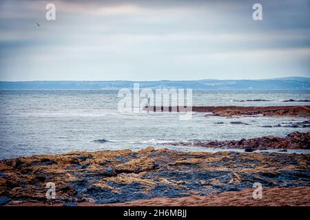 Man takes selfie on the end of some rocks at Porthleven beach, Cornwall, UK Stock Photo