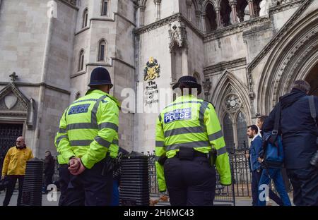 London, UK. 16th Nov, 2021. Police officers stand outside the Royal Courts of Justice during the demonstration. Nine activists are facing prison for breaking an injunction during the recent Insulate Britain protests. The protesters are demanding that the government insulates all social housing by 2025, and takes responsibility for ensuring that all homes in the UK are more energy-efficient by 2030, as part of wider climate change and decarbonization targets. Credit: SOPA Images Limited/Alamy Live News Stock Photo