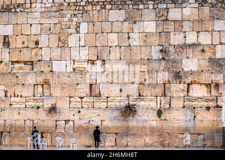 Two small man praxying at teh giant Western Wall Stock Photo