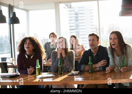 Excited business people sitting in office Stock Photo