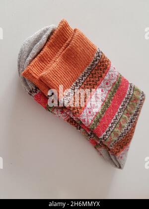 Pair of new warm winter socks with a beautiful pattern on a white table. Stock Photo