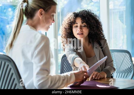 Young woman talking to mature woman in office Stock Photo