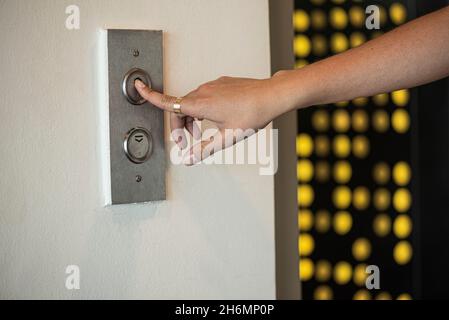 Close-up of woman's finger pressing push button Stock Photo
