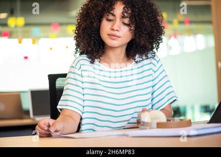 Businesswoman reading documents in office Stock Photo