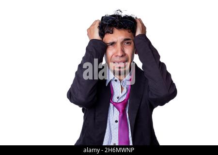 Frustrated and desperate businessman clutching his hair because he lost his job. Young adult about to cry over something bad that happened to him Stock Photo
