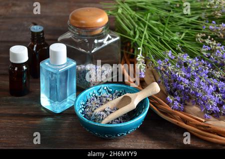 Fresh and dry lavender flowers with bottles of essential oil and lavender water for spa procedures or natural cosmetics production. Aromatherapy and s Stock Photo
