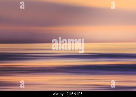 Sunset over the ocean, abstract seascape in bright vibrant purple and pink colors, motion blur, copy space Stock Photo
