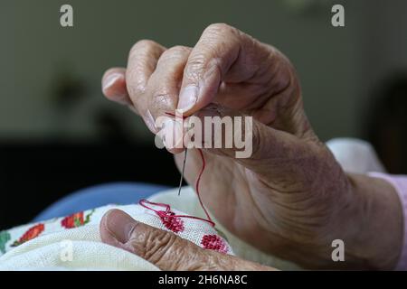 Generic image of  female elderly hands using a needle to sew. Stock Photo