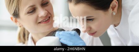 Female scientists chemists looking through microscope in laboratory Stock Photo