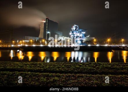 Datteln, Germany. 17th Nov, 2021. A coal ship is unloaded with a mobile unloading device in the early hours of the morning in front of the Unier coal-fired power plant Datteln 4. Credit: Bernd Thissen/dpa/Alamy Live News Stock Photo