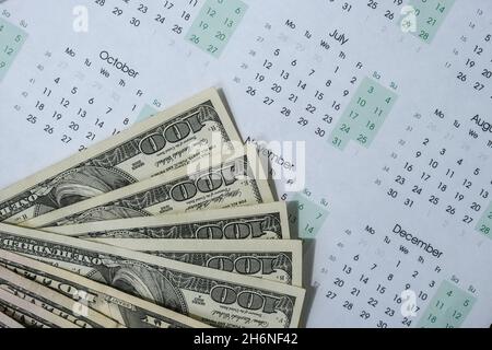 Office workplace desk with dollars and calendar. Counting money for salary. Investment savings. Finances, economy and home concept. Business budget of Stock Photo