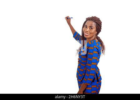 beautiful adult teacher dressed in traditional loincloth writing something on the board smiling Stock Photo