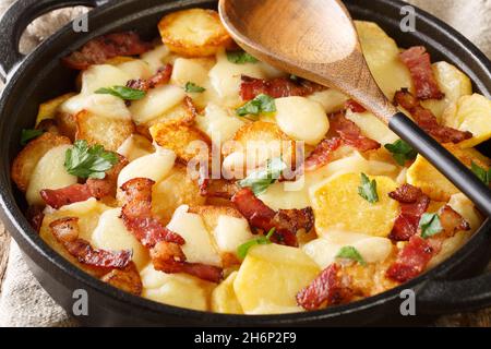 Truffade Potato Cake with Cheese and Bacon Recipe close up in the pan on the table. Horizontal Stock Photo