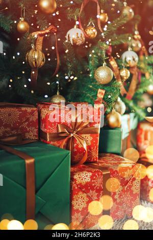 Many gift boxes with sequins standing under a decorated Christmas tree Stock Photo
