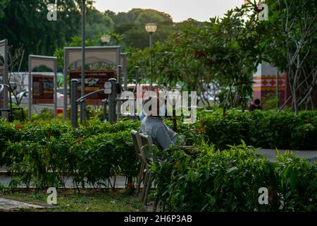 Senior citizen resting at a public park in Little India Stock Photo